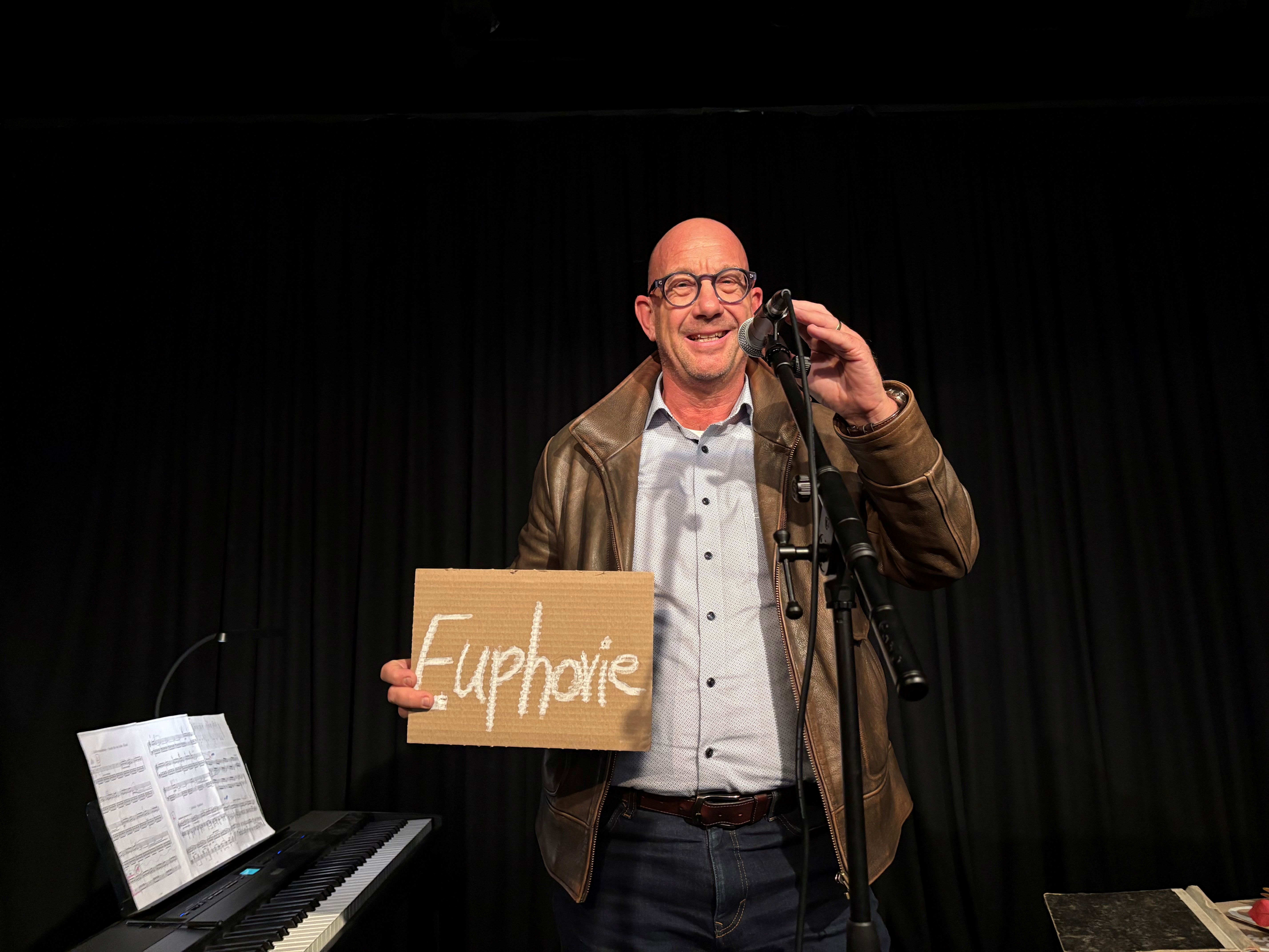 Prof. Selke hält ein Schild in der Hand mit der Aufschrift "Euphorie"