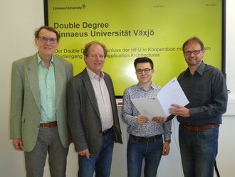  Four men, the second from the right holding an award