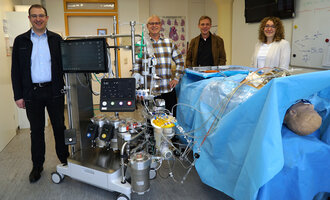 Symbolbild: Die im Text genannten Personen vor der Maschine