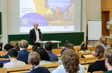 Sprecher vor einem Hörsaal voller Menschen