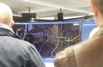 Two people looking at a display showing transport routes