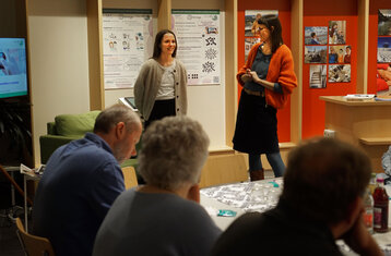 Symbolic photo: 2 women standing in front of a seated audience