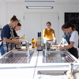 Studierende die in einer Lehrküche etwas kochen