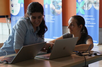Zwei Frauen vor Laptops