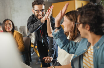 Eine Gruppe Lernender gibt sich High Five