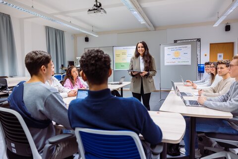 Seminar, Person steht in der Mitte, beantwortet Fragen