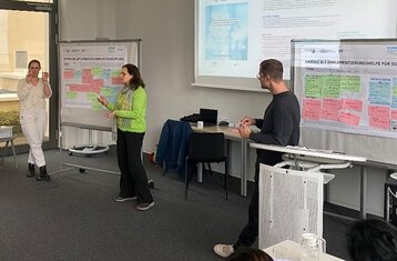 Three people presenting in a lecture theatre