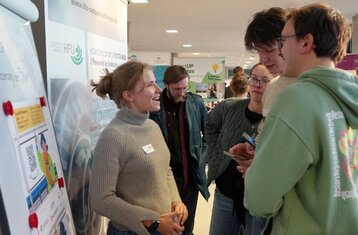 Eine Gruppe von Menschen, die an einem Messestand sprechen