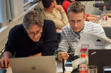 Two teachers focusing on a laptop