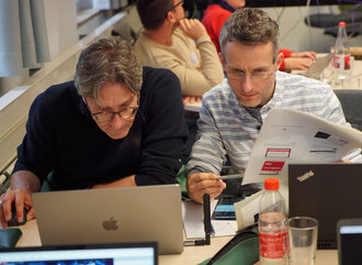 Two teachers focusing on a laptop