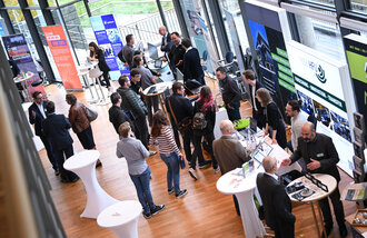 Symbolbild: Ein Blick von oben auf Menschen die an Infoständen stehen