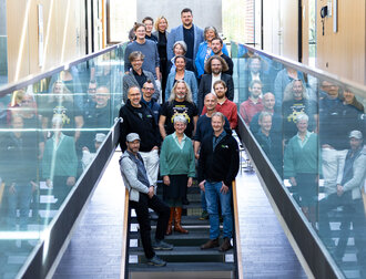 Eine Menschengruppe steht auf einer Treppe im Mediengebäude