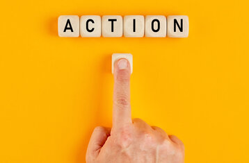 Finger zeigt auf die Buchstaben "Action"