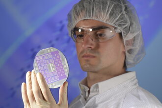 A scientist looks at a silicon wafer