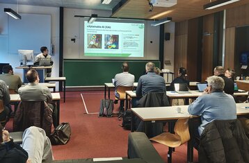 Teilnehmende diskutieren Forschungsprojekte