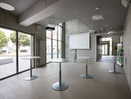 A foyer with several bistro tables