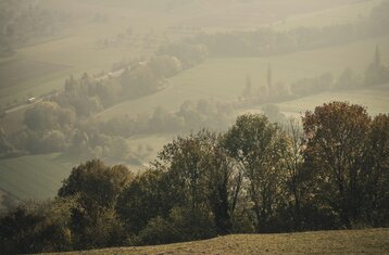 Man sieht eine nebelige Landschaft mit Hügeln