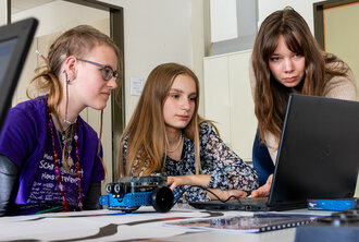 Symbolbild: Drei junge Frauen schauen in einen Bildschirm