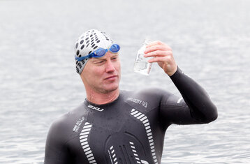 Schwimmer mit Gewässerprobe steht im Fluss