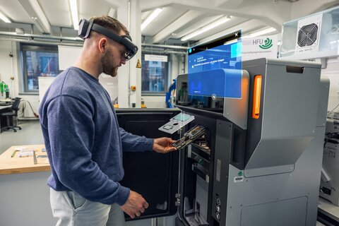 Ein Student mit VR Brille vor einem Display