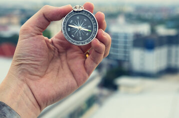 Travel,Concept,Man,Hand,Hold,Metal,Modern,Compass,On,Top