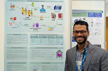 Der junge Mann Urvyn Boochoon steht vor seinem Plakat