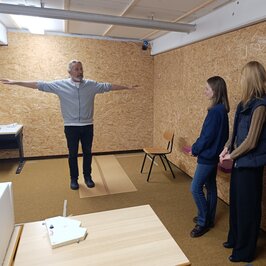 Ein Professor zeigt einer Gruppe einen Raum für VR Games