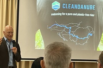 Man sieht einen Mann der vor einer Leinwand steht auf die etwas projiziert wird