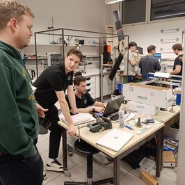 Blick in die Werkstatt mit Personen an verschiedenen Tischen