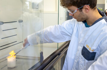 Symbolic photo of a young man conducting a science experiment in a lab