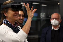 Eine Frau mit VR-Brille hebt eine Hand in Nahaufnahme