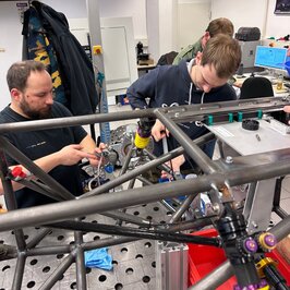 Studierende schrauben an dem Fahrgestänge