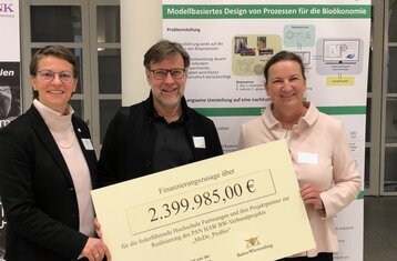 The President, project leader and Head of Administration accept a cheque