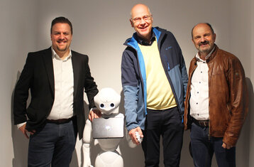 Symbolbild: Die Beteiligten mit Roboter