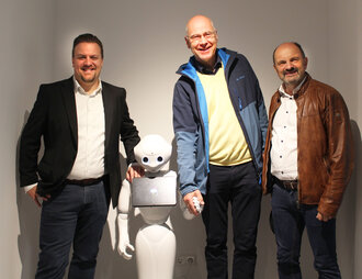 Symbolbild: Die Beteiligten mit Roboter