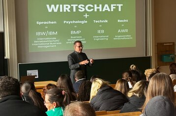 Foto von Dean, der in einem Hörsaal zu potenziellen Studierenden spricht