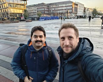 Foto von zwei der Präsentatoren vor dem Gebäude