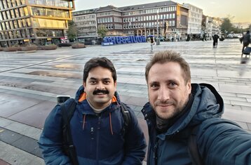 Foto von zwei der Präsentatoren vor dem Gebäude