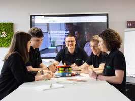 Several people working on a Lego prototype at a table