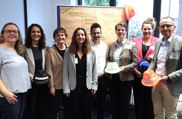 Acht Personen vor einer Metaplanwand