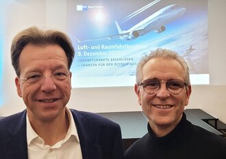 Zwei Personen vor einer Präsentation mit dem Kongresstitel