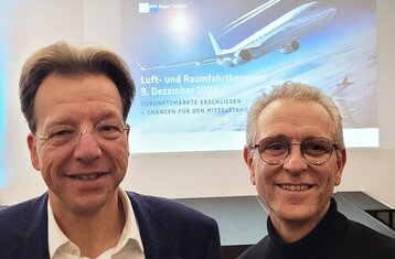 Zwei Personen vor einer Präsentation mit dem Kongresstitel