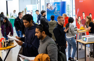 Studierenden-Gewimmel vor Unternehmensständen