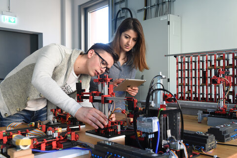 Zwei Personen bauen einen Prototypen für eine Industrieanlage