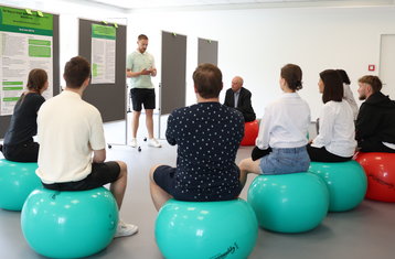 Man sieht Menschen auf Sitzbällen in einem Kreis sitzen