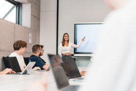 [Translate to English:] Eine Studentin präsentiert vor einer Studierenden Gruppe