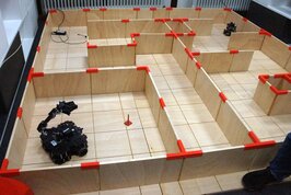 Ein Roboter mit Rädern in einem Holzlabyrinth