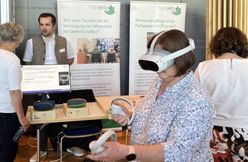 Symbolic photo of woman wearing VR glasses on an exhibition stand