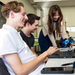 Zwei Jungen und eine Frau vor einem Laptop