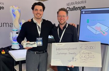 Zwei Personen mit einem großen Scheck über 25.000 Euro